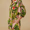 up close of model wearing pink jumpsuit with pockets, collar and all over banana leaves print