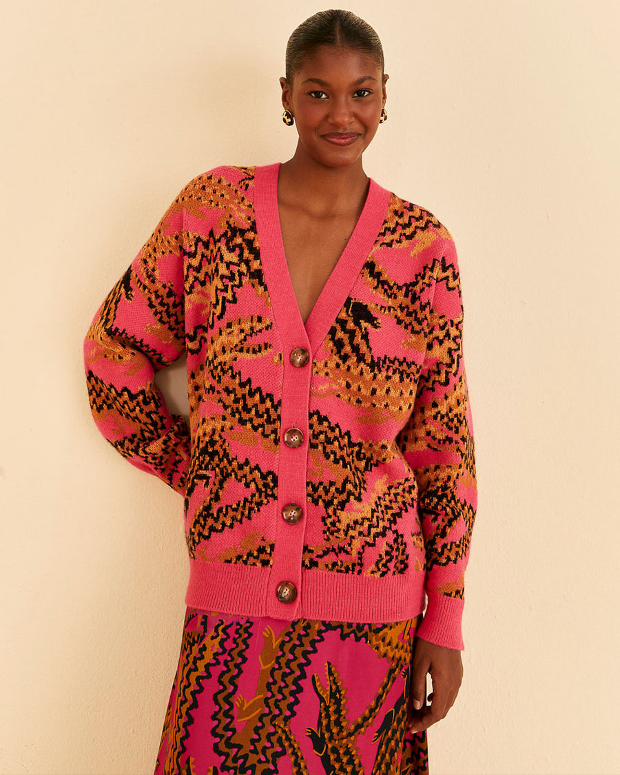 model wearing pink cardigan with croc print and large tortoise buttons