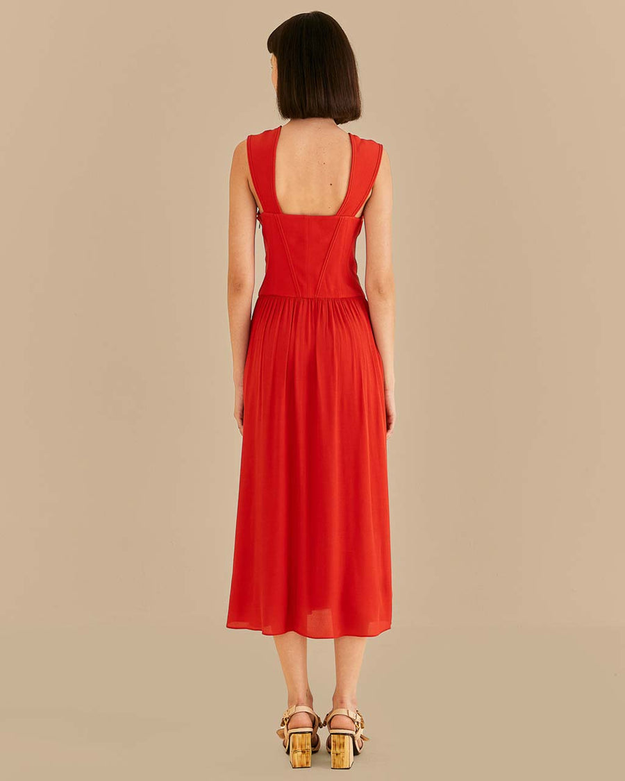back view of model wearing red midi dress with thick straps and cut out bow detail