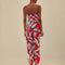 back view of model wearing red tank jumpsuit with green leaf print and cuffed leg openings