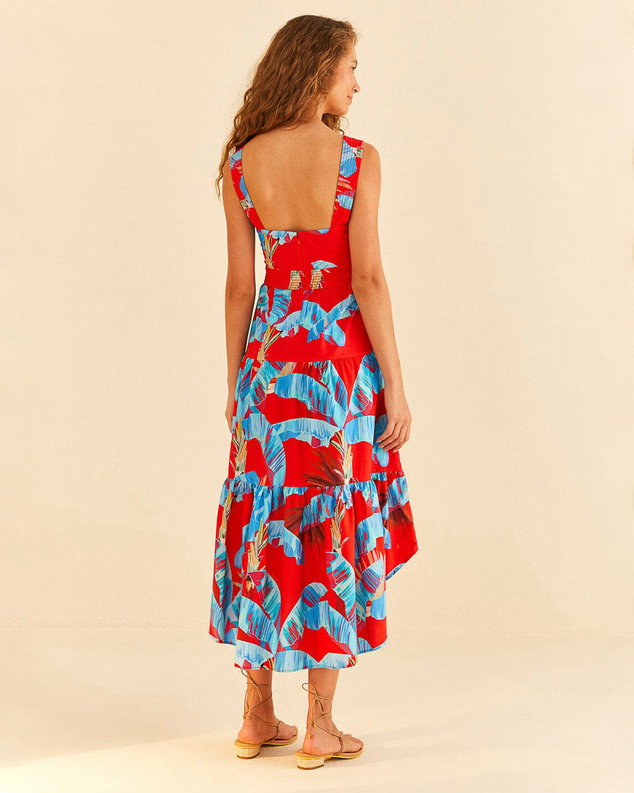 backview of model wearing red tiered midi dress with blue palm leaf print
