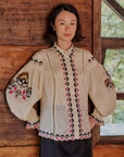 model wearing cream blouse with button front, and all over floral embroidery down the front, sleeves and back