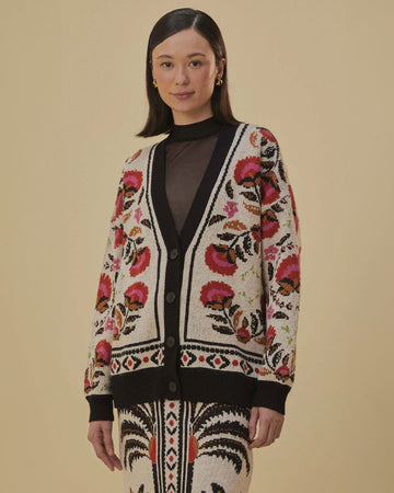 model wearing sand cardigan with pink and red abstract floral print and black trim
