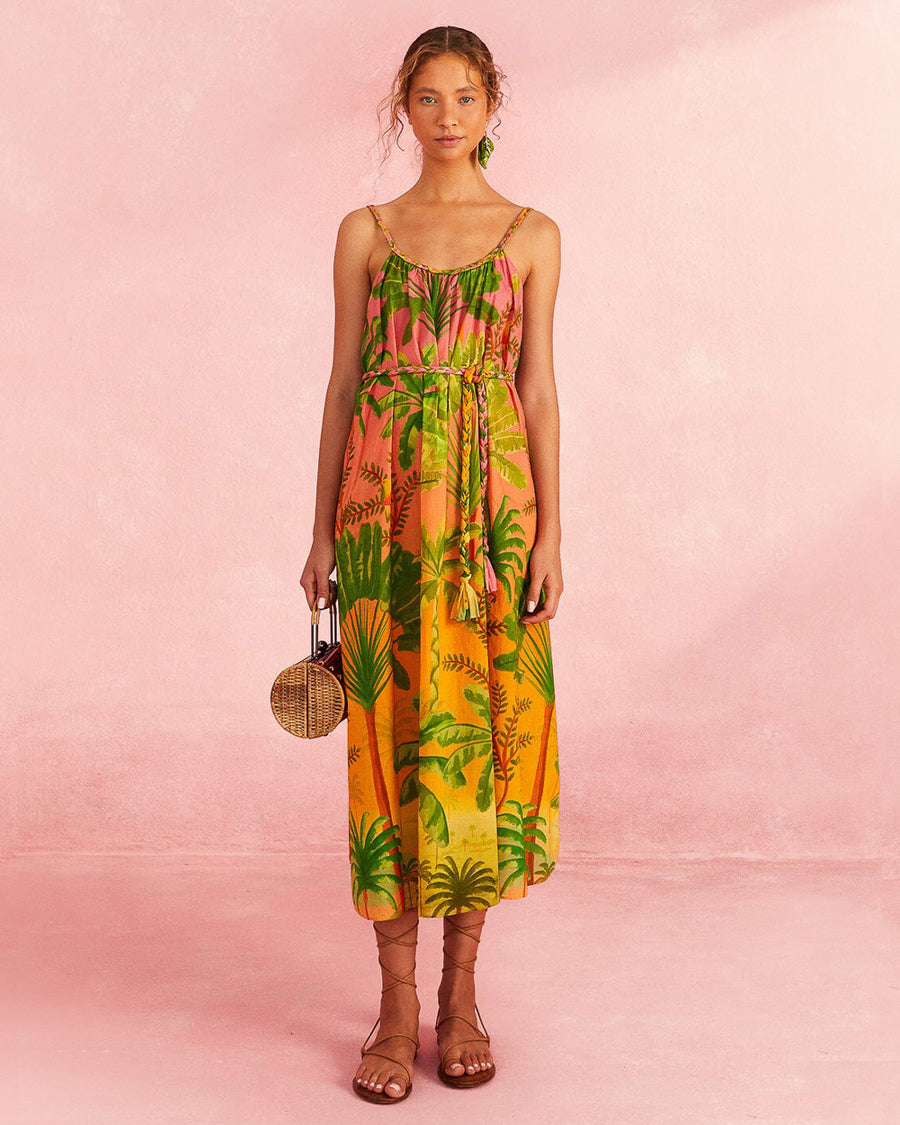 model wearing pink and orange ombre midi dress with vibrant tropical print and rope like belt and straps