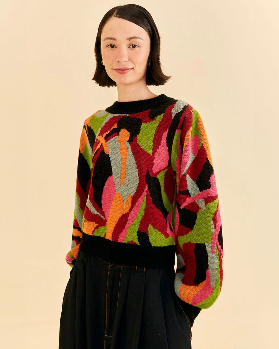 model wearing colorful sweater with black neckline, cuffs and waistband