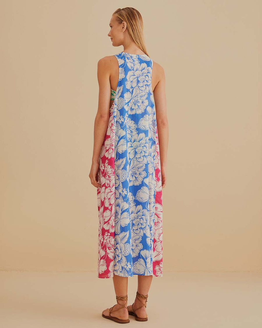 back view of model wearing colorful floral patchwork midi dress with pom seam detail and pockets