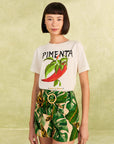 model wearing nude shorts with tropical leaf print, bamboo belt, and white pepper tee