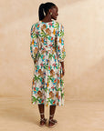 backview of model wearing cream midi skirt with colorful bird print and bamboo fabric belt with matching top