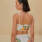 back view of model wearing white cropped top with eyelet and colorful floral detail