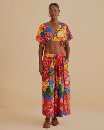 model wearing blue cotton midi skirt with yellow, red and orange cold floral print, side pockets and tie waist and matching cropped top