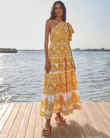 model wearing yellow and white abstract print one shoulder maxi dress