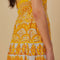 up close of model wearing yellow and white abstract print one shoulder maxi dress