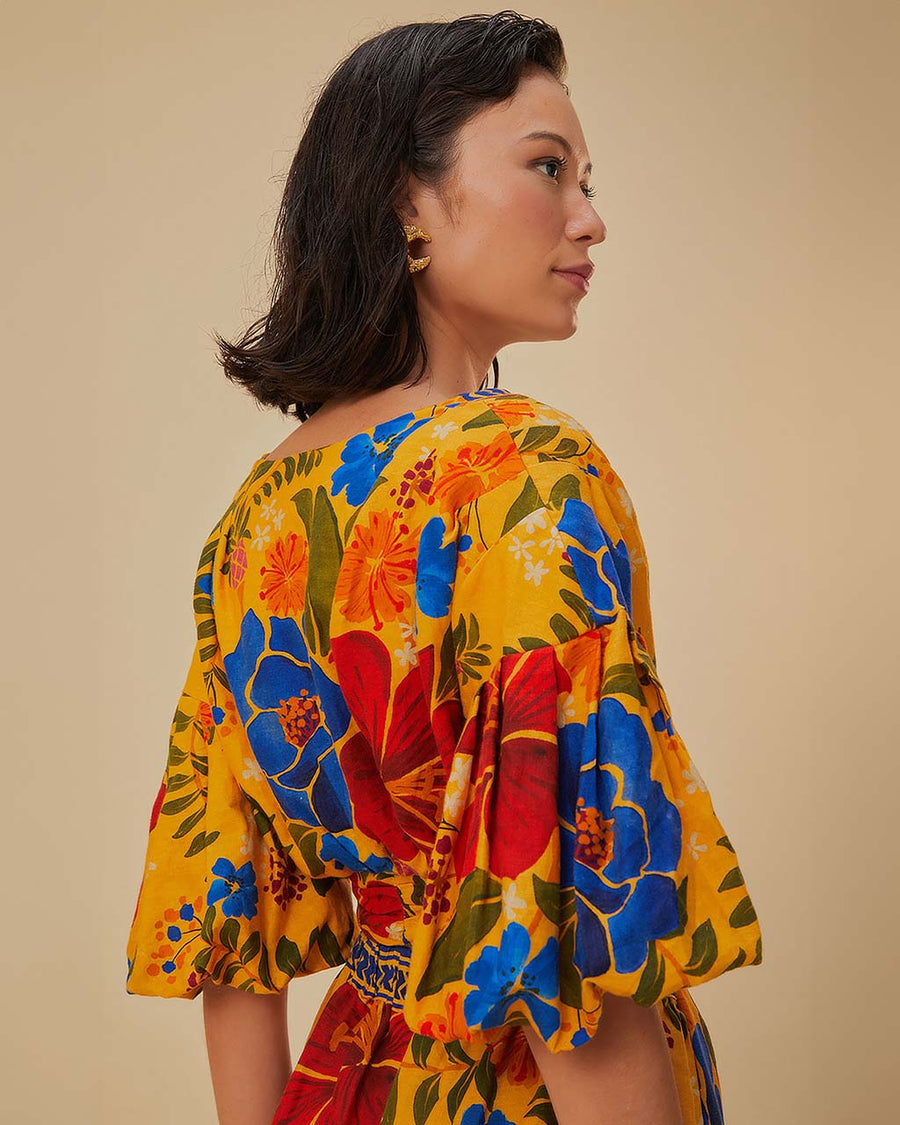 up close of model wearing yellow cropped top with bold colorful floral print and puff sleeves