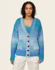 model wearing blue gradient oversized cardigan with patch pockets and brown button front