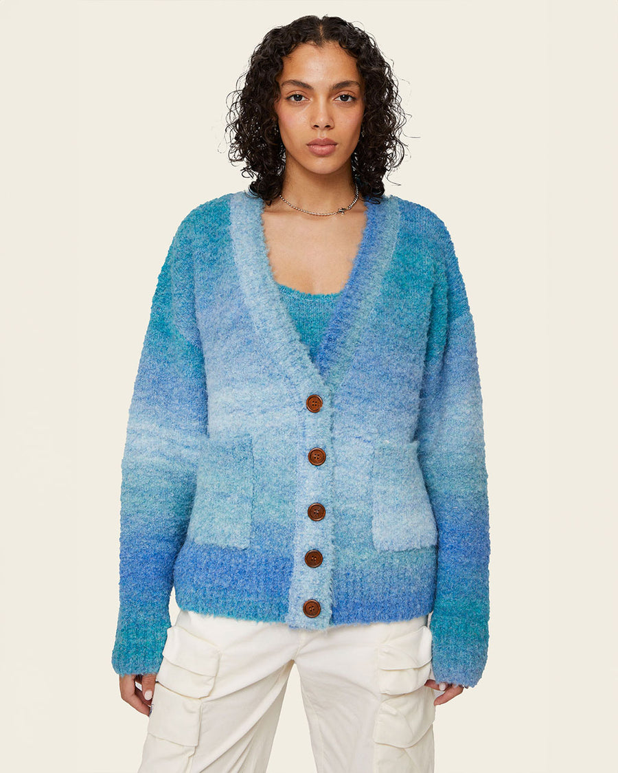 model wearing blue gradient oversized cardigan with patch pockets and brown button front