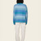 back view of model wearing blue gradient oversized cardigan with patch pockets and brown button front