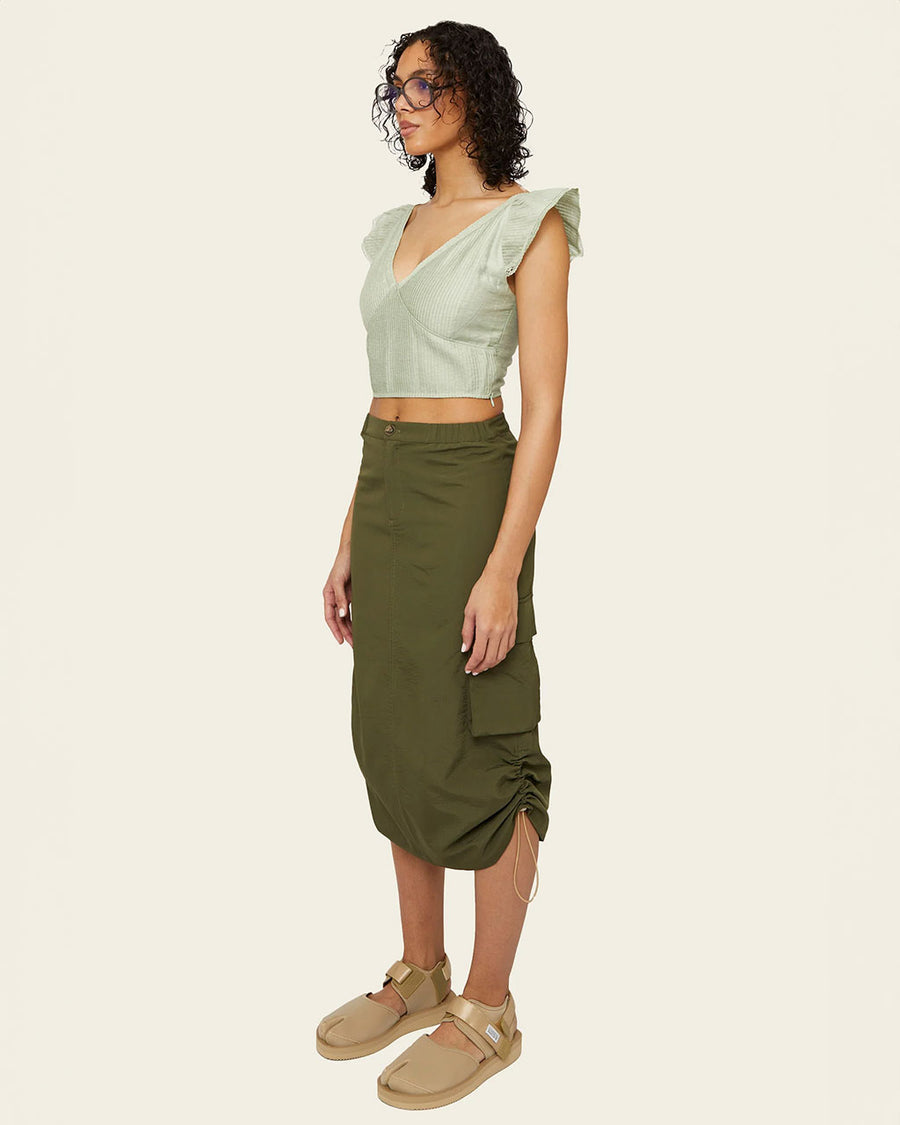 side view of olive green midi skirt with adjustable bungee sides and cargo pockets
