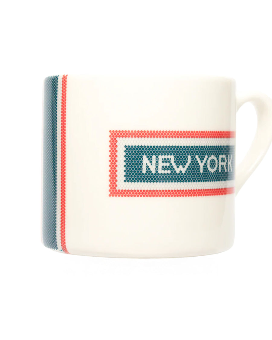 side view of cream coffee mug with red and blue subway tile 'NEW YORK' across the front