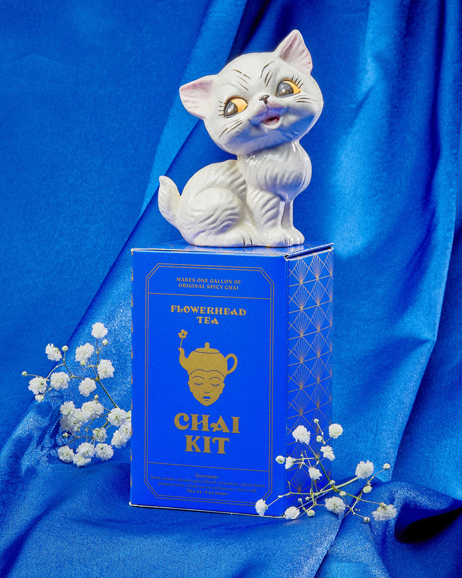 box of 10 serving chai kit (makes on gallon of original spicy chai) with white cat figurine on the top