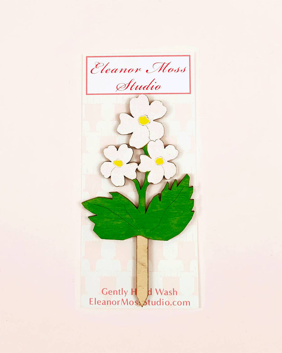 wooden cake topper with a bundle of white flowers and greenery 