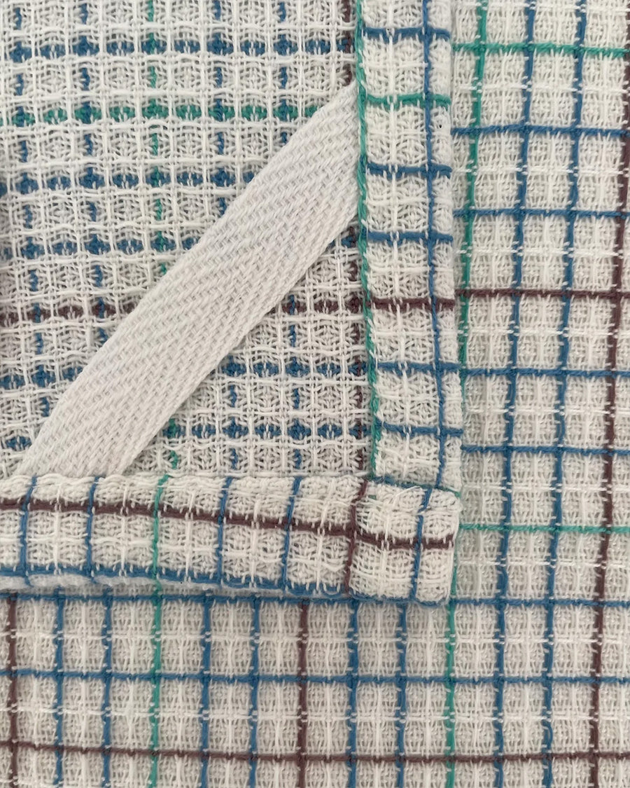 hanger of set of two woven dishcloths: white with blueberry print and white with plaid in blue, green and burgundy