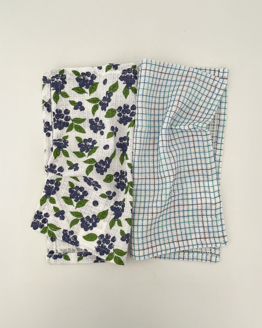 set of two woven dishcloths: white with blueberry print and white with plaid in blue, green and burgundy