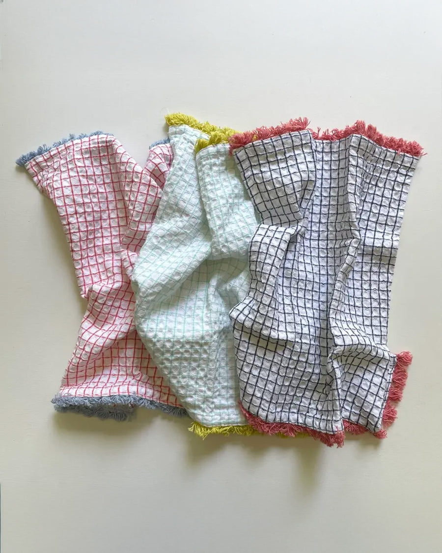 set of three plaid dishcloths with fringe: red with blue fringe, mint with yellow fringe, and navy with rose fringe