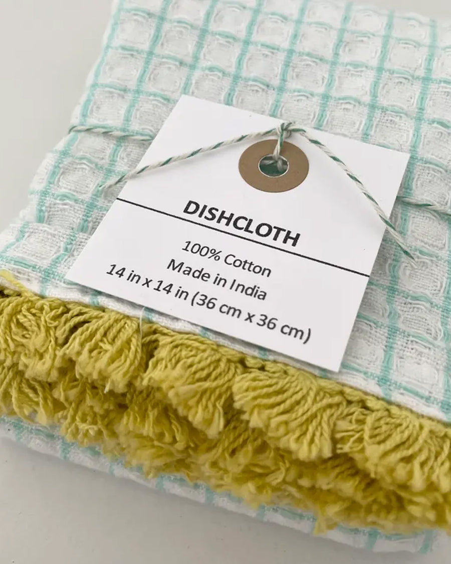 packaged set of three plaid dishcloths with fringe: red with blue fringe, mint with yellow fringe, and navy with rose fringe