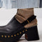 side view of model wearing black leather clogs with gold stud details at the sole