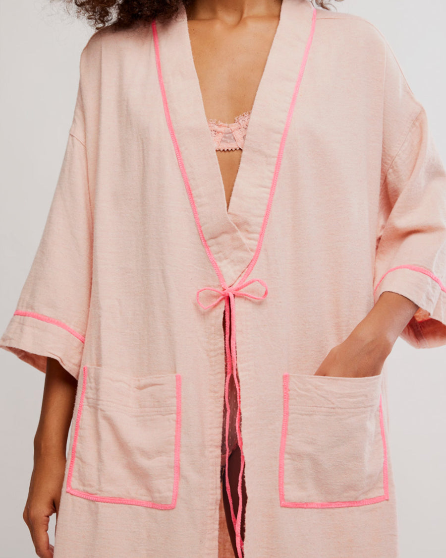 up close of model wearing pink long robe with bright pink trim