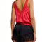 back view of model wearing bright red cotton tank with button front and lace applique detail down the front and hem