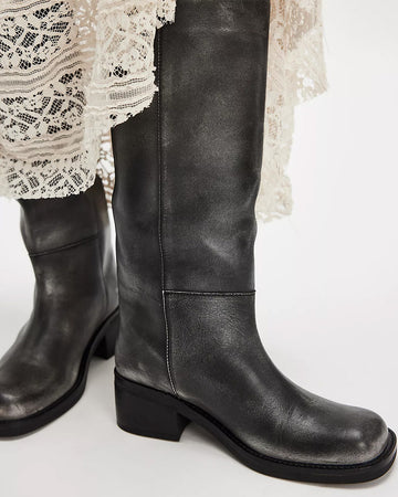 model wearing black distressed leather pull-on tall boots