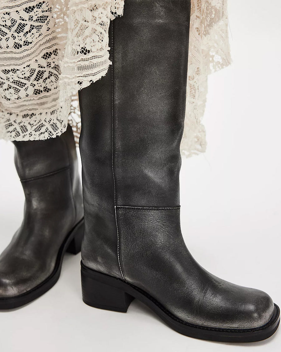 model wearing black distressed leather pull-on tall boots