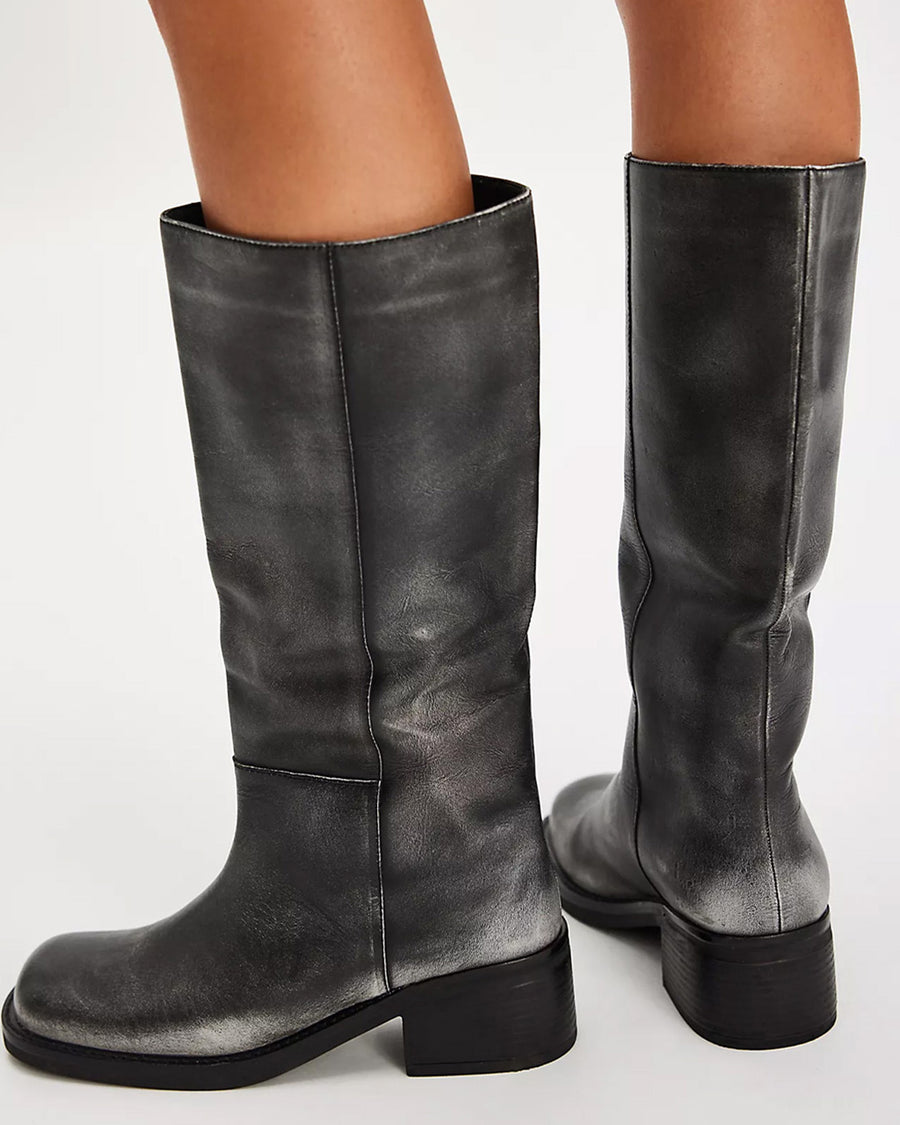 back view of model wearing black distressed leather pull-on tall boots