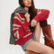 model wearing red sweater with white and orange stripes