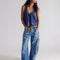 model wearing medium denim barrel jeans with faded sun print design