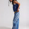 side view of model wearing medium denim barrel jeans with faded sun print design