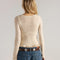 back view of model wearing cream woven cardigan with criss-cross details and ruffles on the hem and sleeves