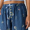 up close of model wearing navy pinstripe balloon lounge pants with white dainty floral print