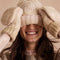 model wearing thick knit ivory winter hat with pom and fingerless gloves/mittens