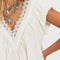 up close of model wearing cream cotton mini dress with crochet scalloped deep v-neckline and cap sleeves