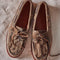 top view of taupe suede slip on boat shoe with tie top and fringe detail