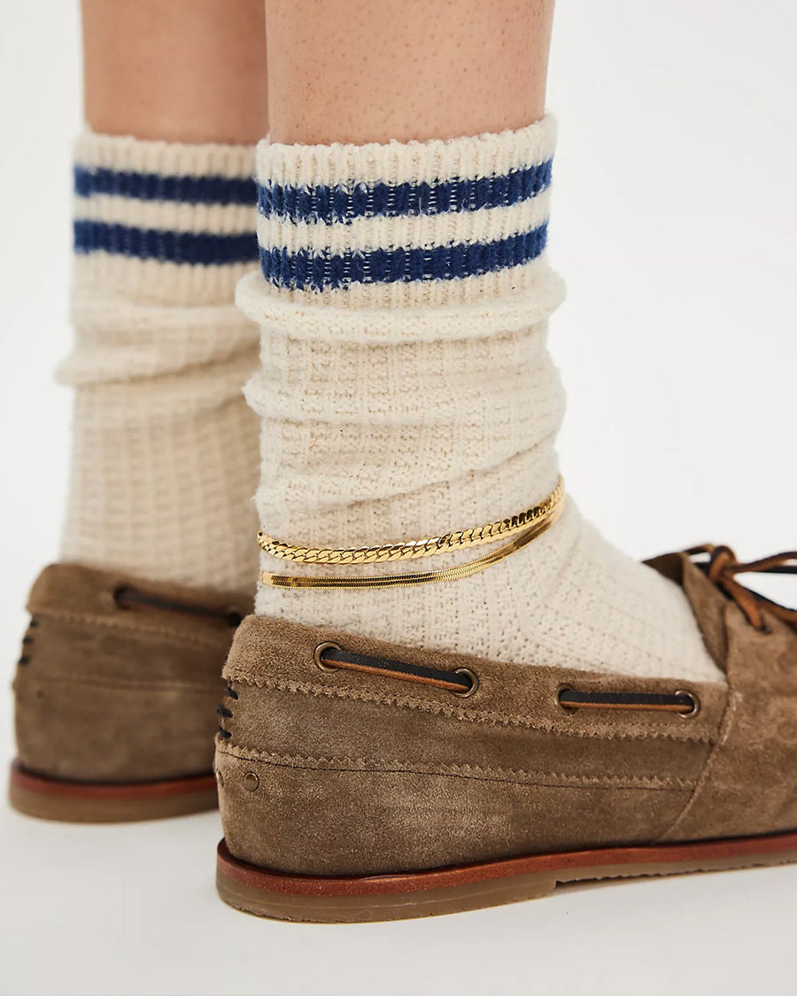 back view of model wearing taupe suede slip on boat shoe with tie top and fringe detail