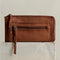 back view of model holding brown leather zip wallet with braided zipper pull