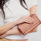 model holding brown leather zip wallet with braided zipper pull