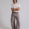 model wearing muted brown leopard barrel print jeans