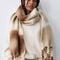 model wearing cream brown and tan oversized scarf with thick fringe on the end