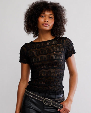 model wearing black lace short sleeve top with leather pants