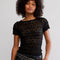 model wearing black lace short sleeve top with leather pants