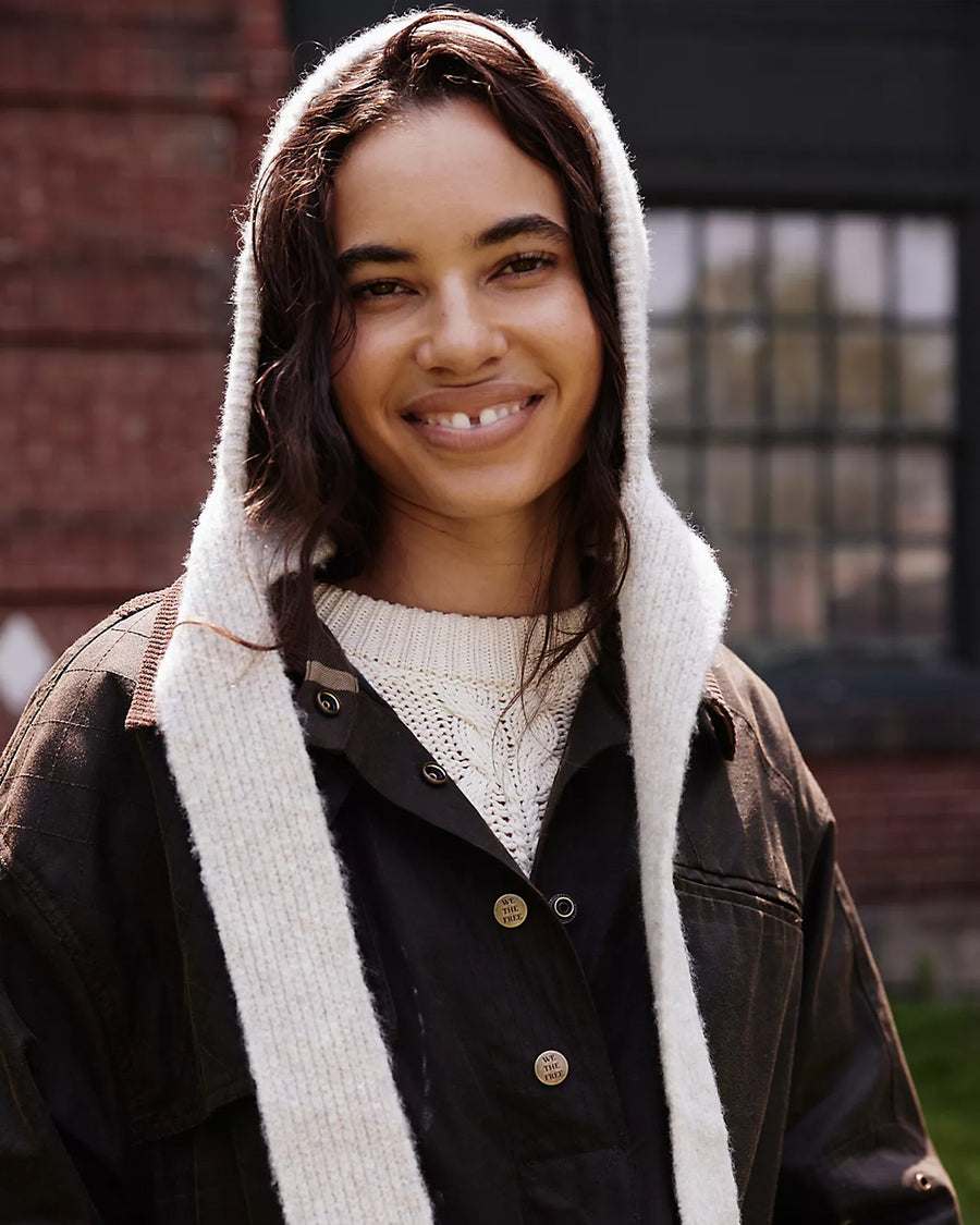 front view of model wearing oatmeal knit bonnet with tie straps
